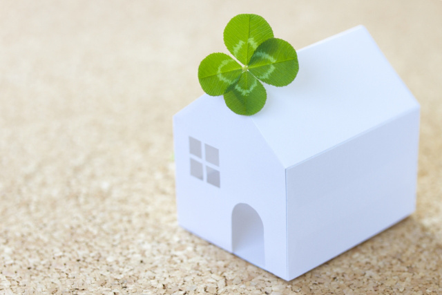 家のフィギュアの上の四葉のクローバー